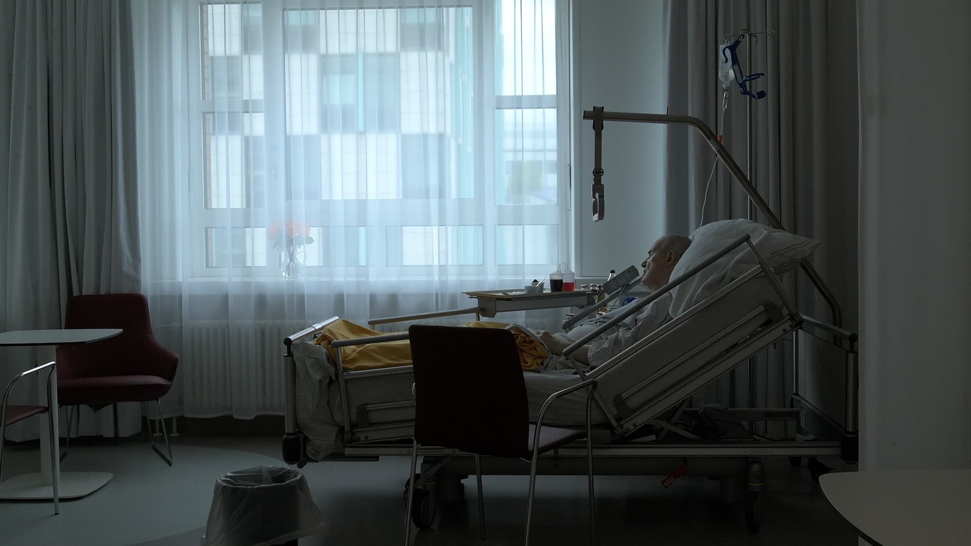 Älterer Mann liegt in einem Krankenhauszimmer
